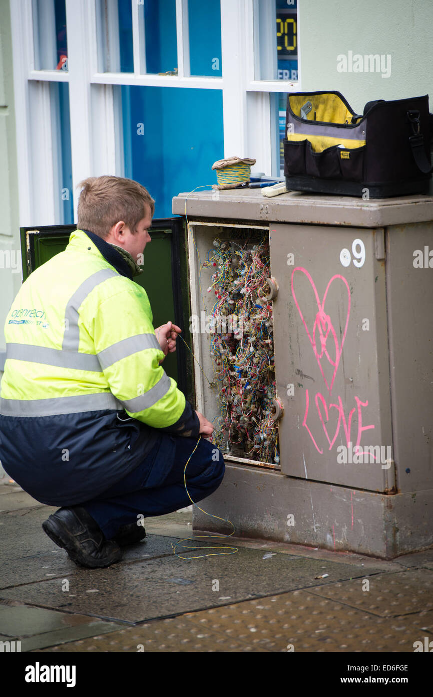 La prise de décision : UN BT Openreach telecoms ingénieur travaillant sur un raccordement à bande large cabinet de rue. UK Banque D'Images