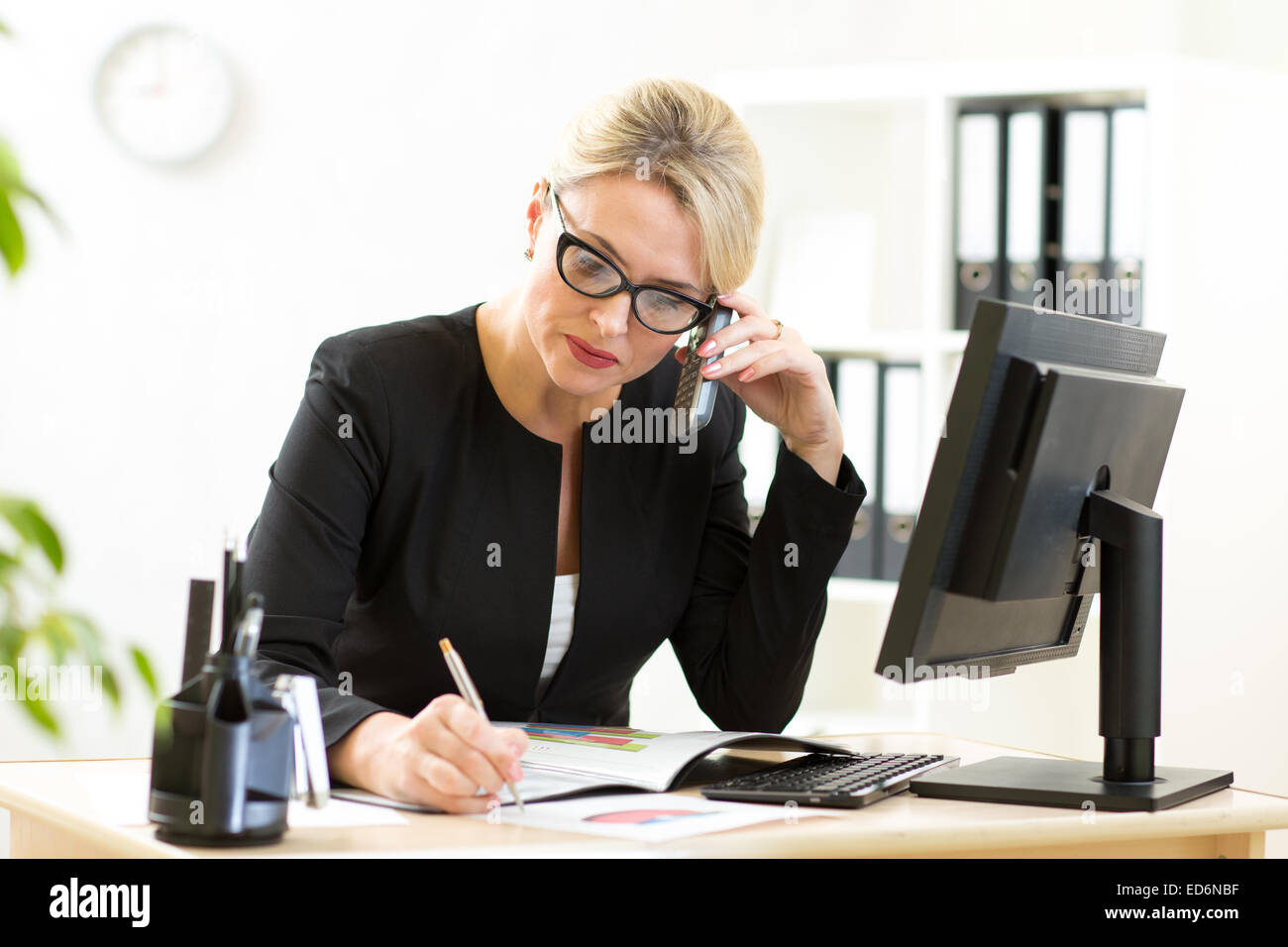 Middle-aged business woman working in office phone Banque D'Images