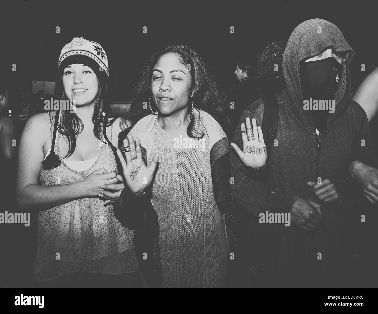 Trois manifestants bras de verrouillage de bloquer une gare Amtrak. Les femmes du milieu protestataire a don't shoot écrit sur ses mains. Banque D'Images