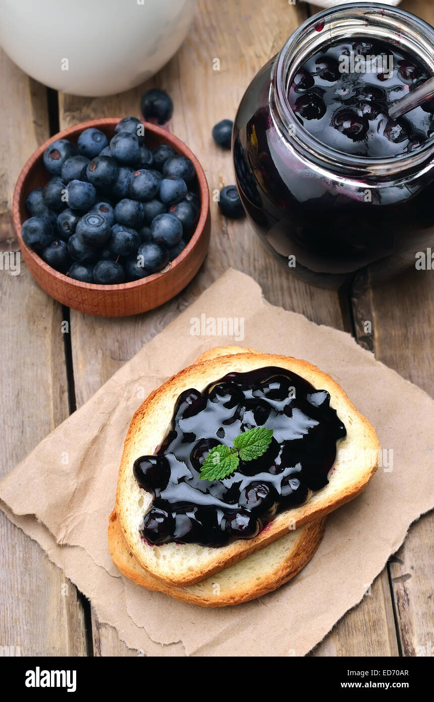 Confiture sur des toasts de pain sur table en bois Banque D'Images