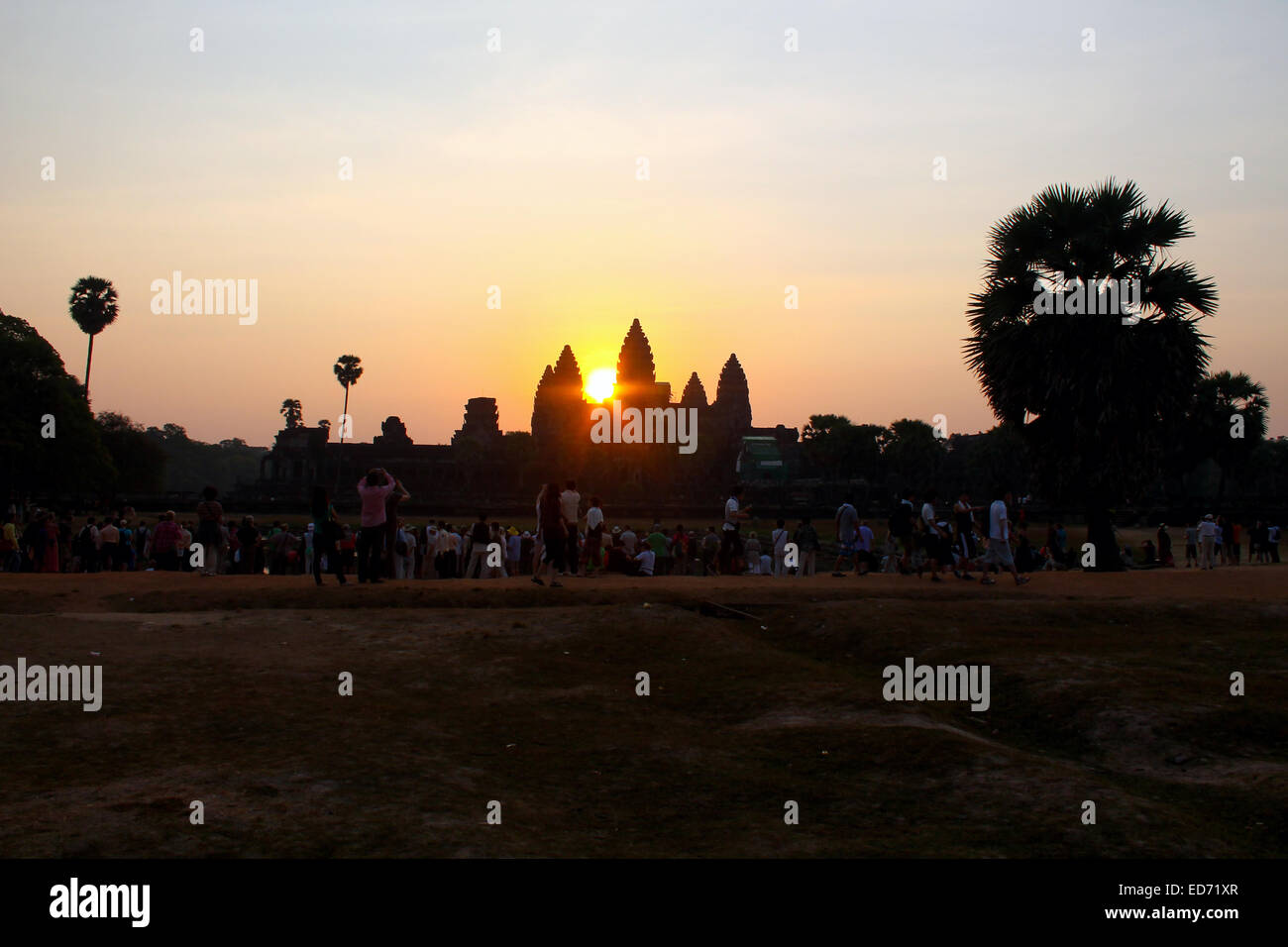 Les touristes regarder sur comme le soleil se lève sur Angkor Wat. Banque D'Images