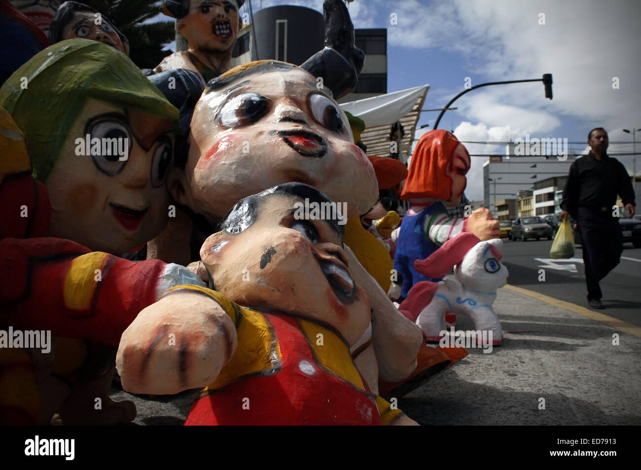 Quito, Equateur. Dec 30, 2014. Un homme marche en avant des figures de film et télévision caractères affichés à vendre dans la ville de Quito, Équateur, le 30 décembre 2014. Les chiffres réalisés en carton sera mis le feu dans le cadre de la tradition locale pour 'brûler' la vieille année de manière à laisser derrière l'expérience négative de l'année dernière et bienvenue la nouvelle année. © Santiago Armas/Xinhua/Alamy Live News Banque D'Images
