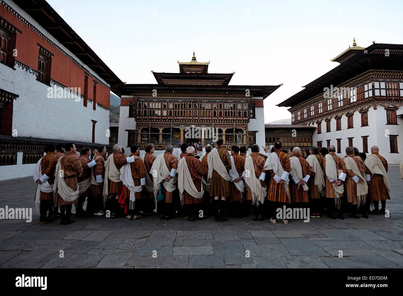 Un groupe de touristes portant des vêtements traditionnels bhoutanais à la Cour de Tashichho Dzong forteresse siège du gouvernement du Bhoutan depuis 1952 et abrite actuellement la salle du trône et les bureaux de Le roi au bord de la ville de Thimphu Au Bhoutan Banque D'Images