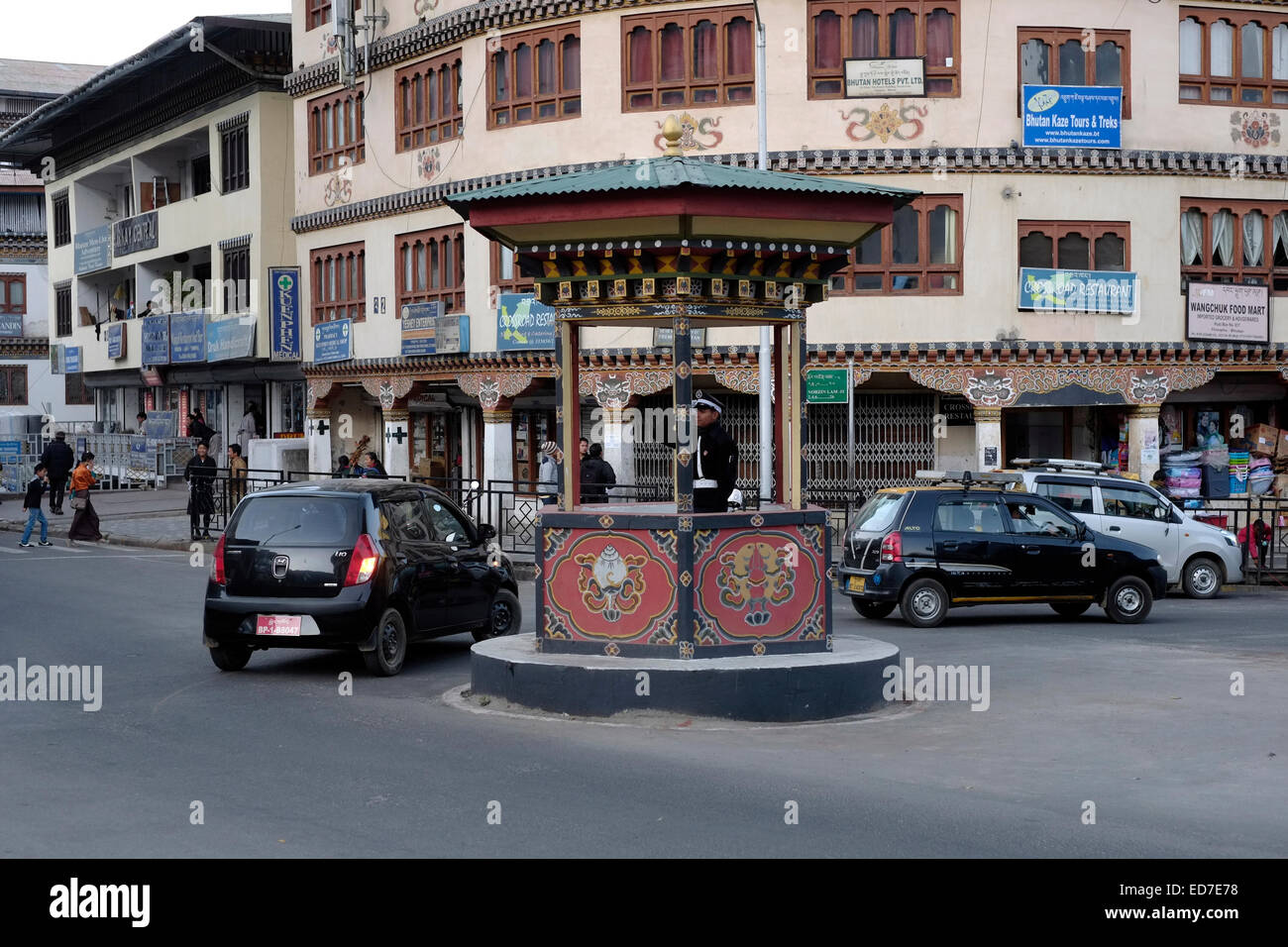 Un policier à globes blancs de la Royal Bhutan police dirige et contrôle la circulation alors qu'il se trouve dans une cabine décorative au rond-point connu sous le nom de « cercle de circulation » dans la ville de Thimphu dit être l'une des deux seules capitales du monde sans feux de signalisation. Bhoutan Banque D'Images