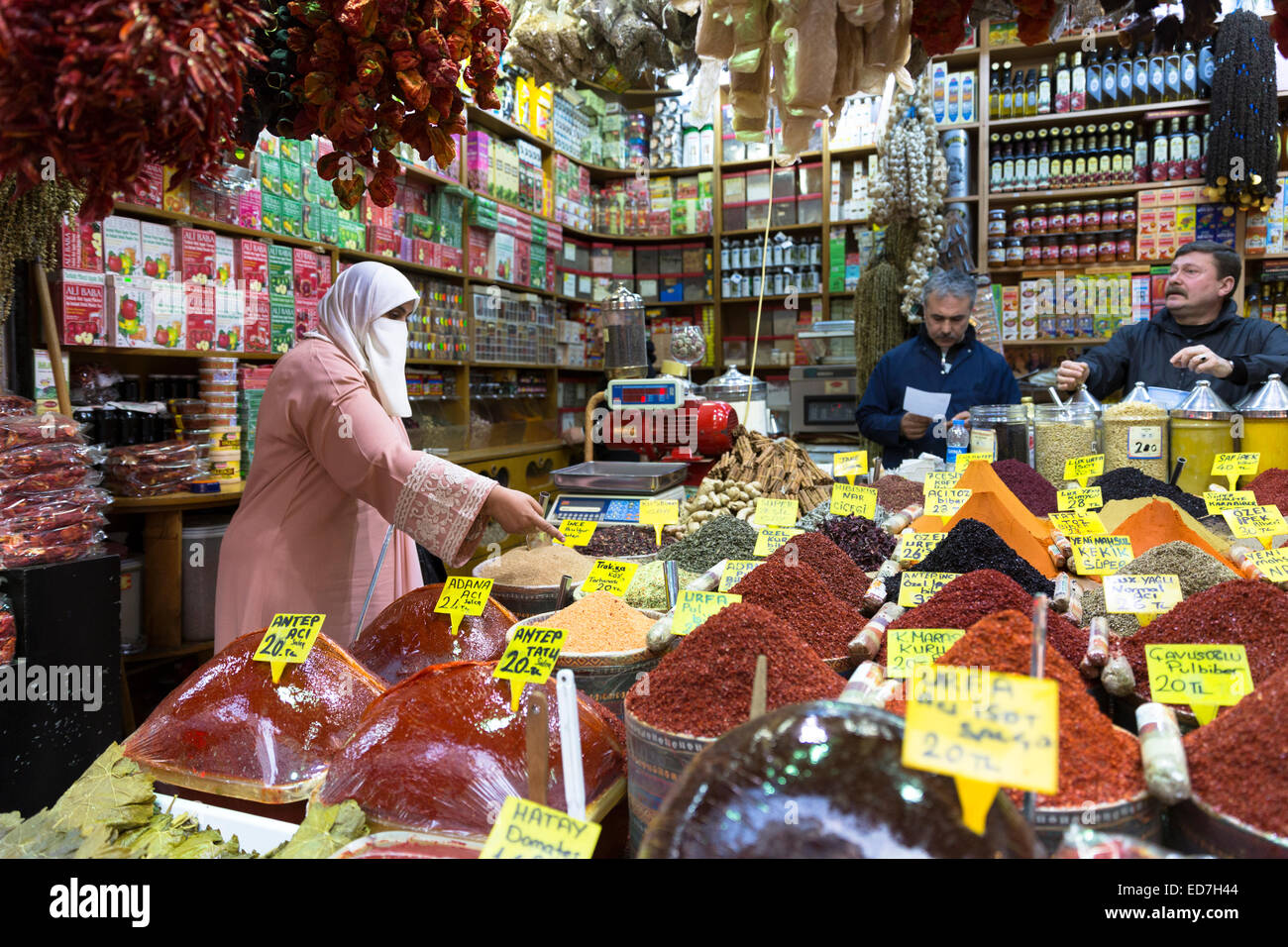 Woman shopper portant voile musulman achète épices Misir Carsisi au bazar égyptien de l'alimentation et le marché aux épices, Istanbul, Turquie Banque D'Images