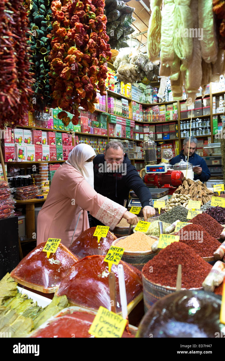 Woman shopper portant voile musulman achète épices Misir Carsisi au bazar égyptien de l'alimentation et le marché aux épices, Istanbul, Turquie Banque D'Images