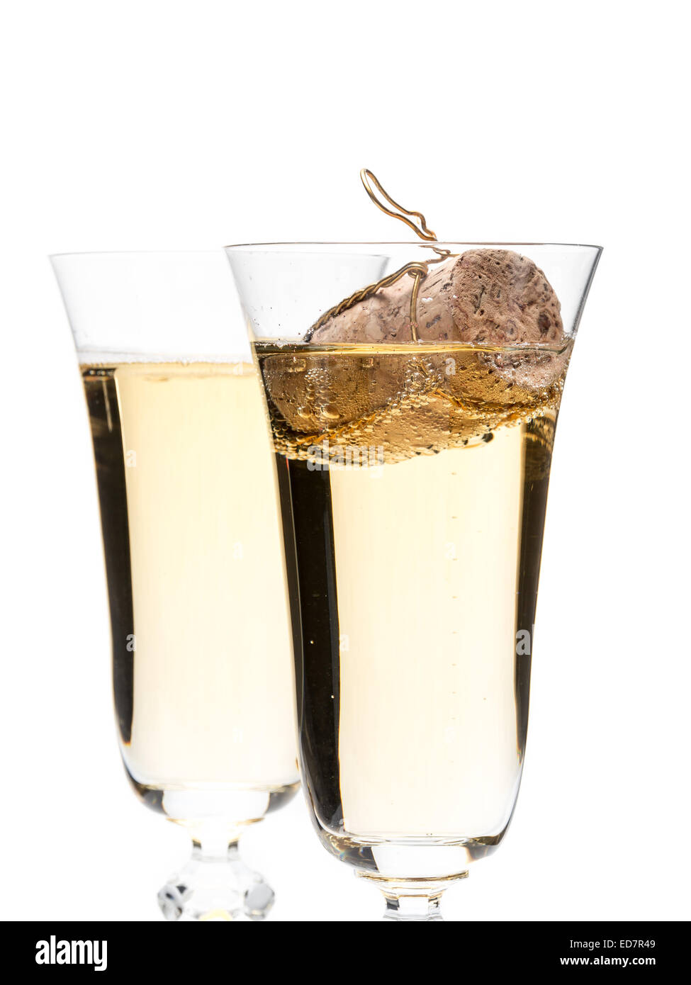 Libre de deux verres de champagne avec bouchon de champagne flottant dans un verre shot on white Banque D'Images