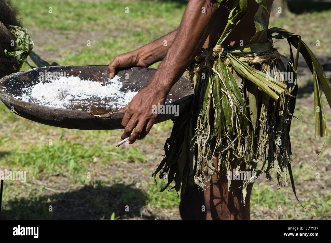 En Mélanésie, la Papouasie-Nouvelle-Guinée, l'île de Dobu. L'homme en habits palm Village holding bol en bois avec du riz. Banque D'Images