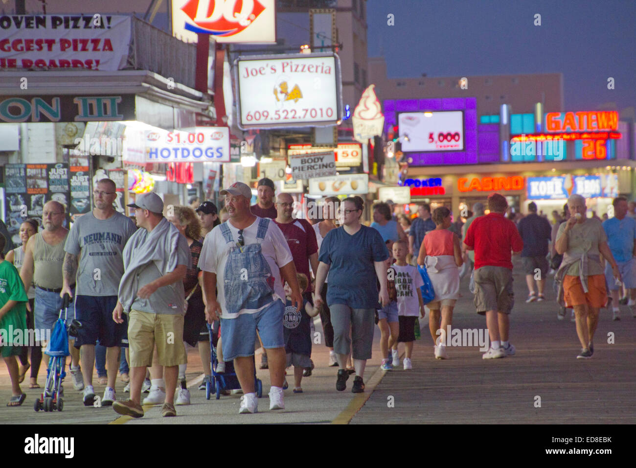 Une foule de touristes à pied les deux mille de long, Wildwood NJ boardwalk bordée de restauration rapide, boutiques et autres divertissements au crépuscule Banque D'Images