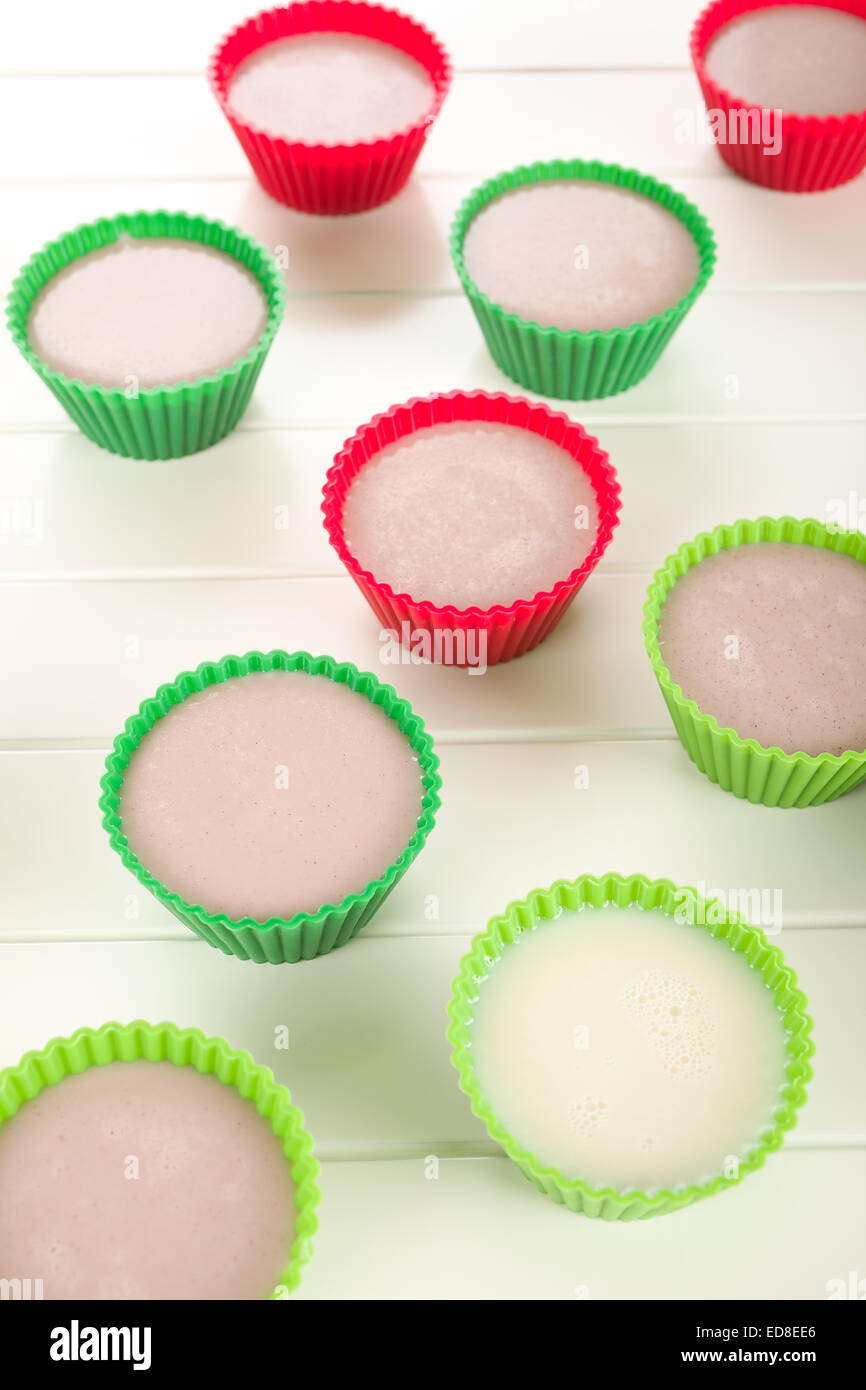 Dessert pudding marron dans un muffin tasse rouge ou vert. Banque D'Images