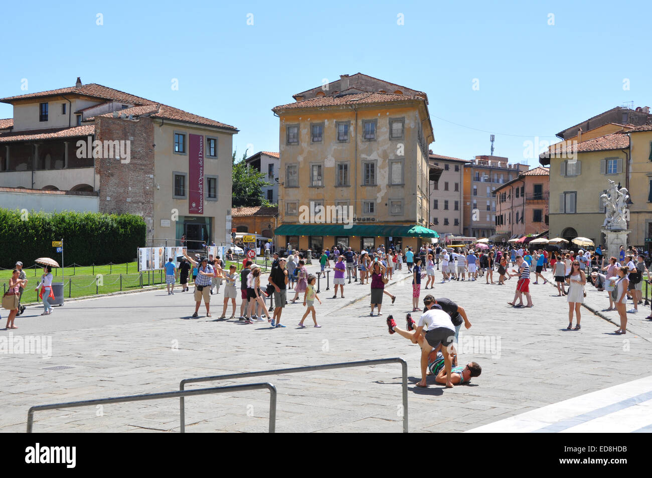 Les touristes à Pise portant sur le plancher pour créer des photographies avec tour de Pise Banque D'Images