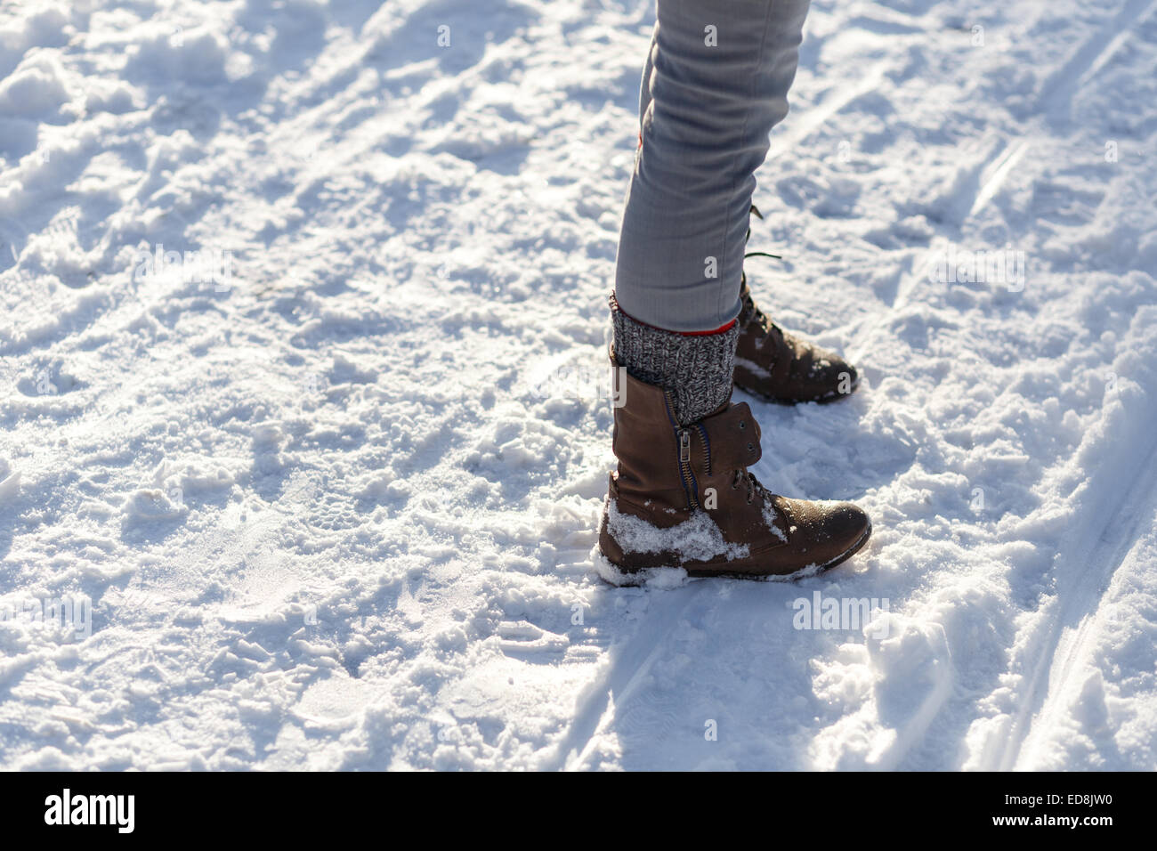 Les jambes de fille Slim dans des bottes dans la neige de l'hiver. Banque D'Images