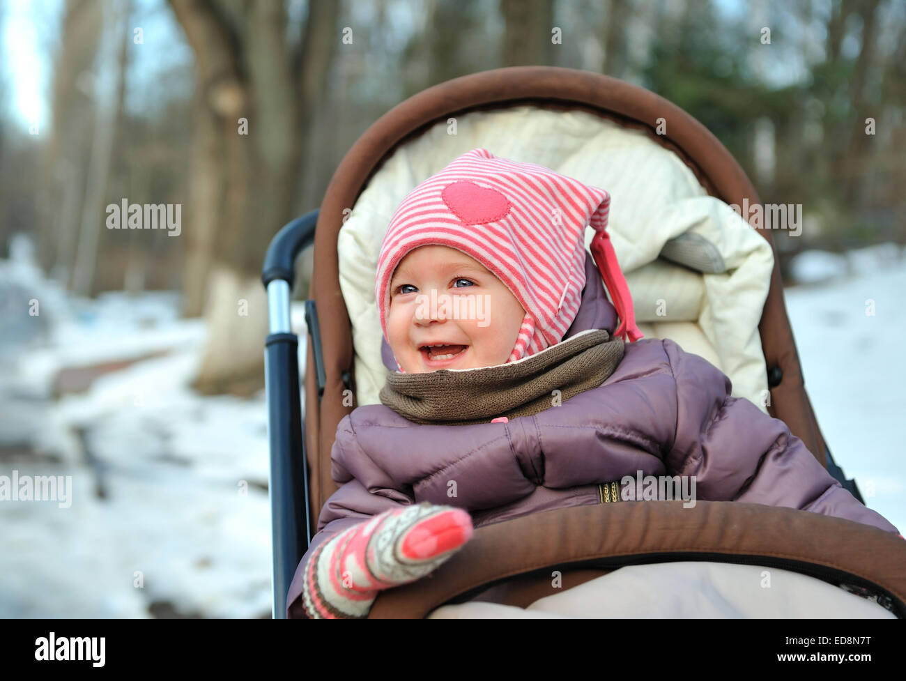 Petite fille dans un fauteuil roulant smiling in journée d'hiver Banque D'Images