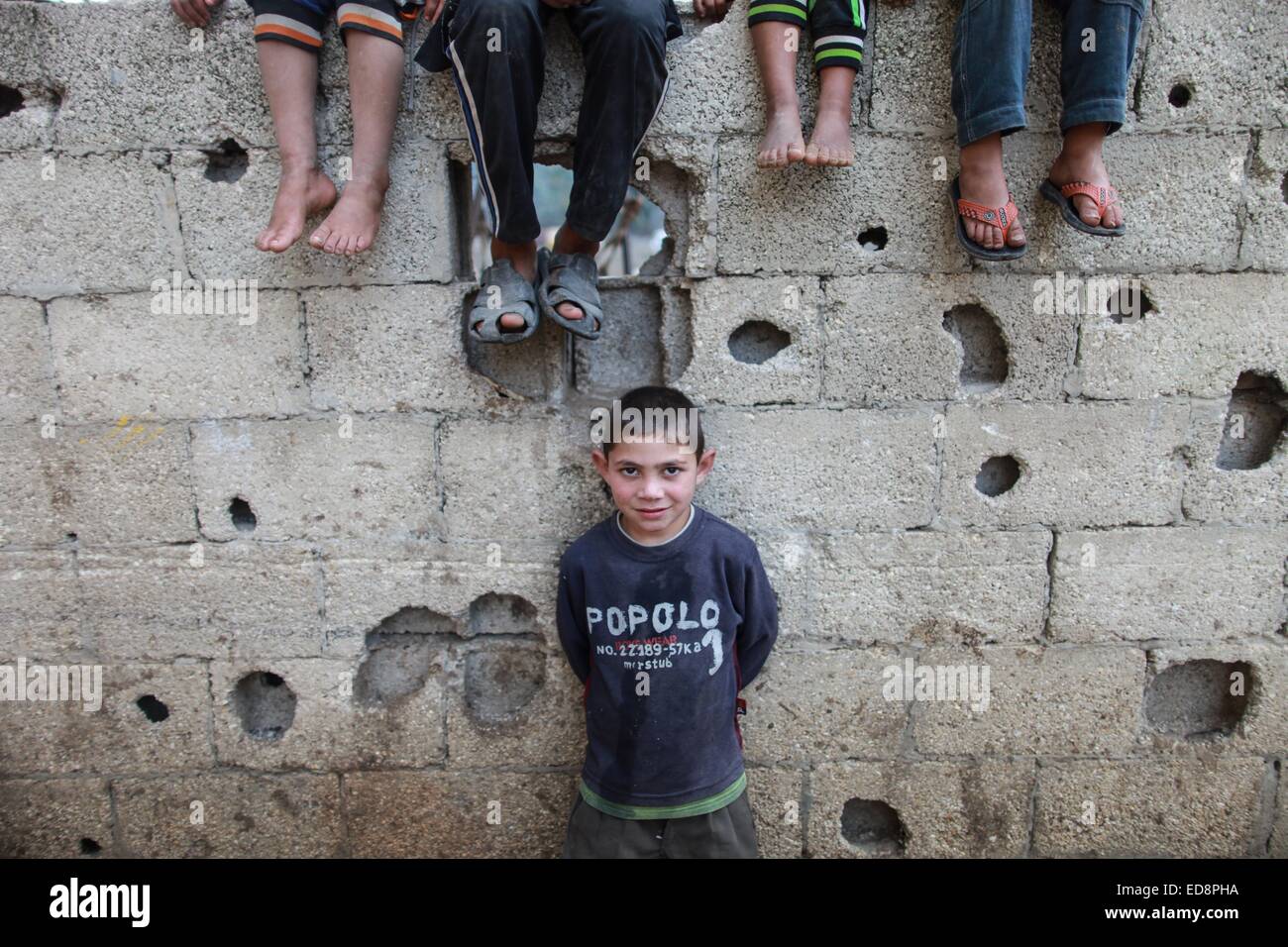 La bande de Gaza. 1er janvier 2015. Un garçon joue dans un quartier pauvre du nord de la bande de Gaza ville de Beit Lahiya au 1er janvier 2015. Les statistiques récentes de la Fédération générale palestinienne des syndicats (PGFTU) ont révélé que le taux de chômage à Gaza s'élève à 200 000 personnes. Al-Amasi sami, le président de la PGFTU à Gaza, a déclaré ce qui représente une augmentation de 30 000 personne depuis avant la dernière guerre avec Israël, une situation qui est "le pire dans dix ans. © Wissam Nassar/Xinhua/Alamy Live News Banque D'Images