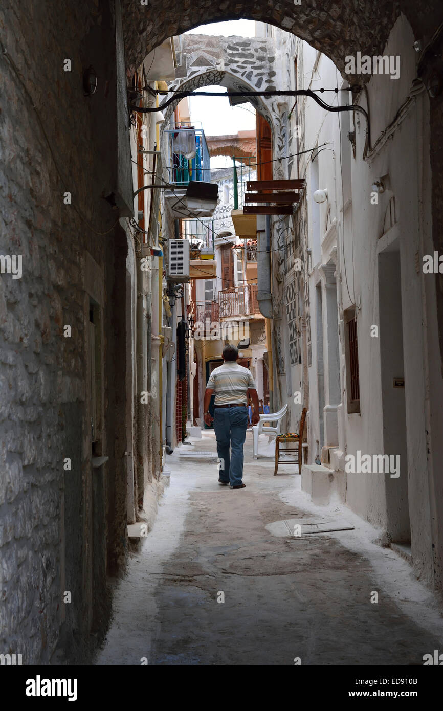Homme marchant le long de la rue étroite au calme dans le village de Pyrgi, Chios Banque D'Images