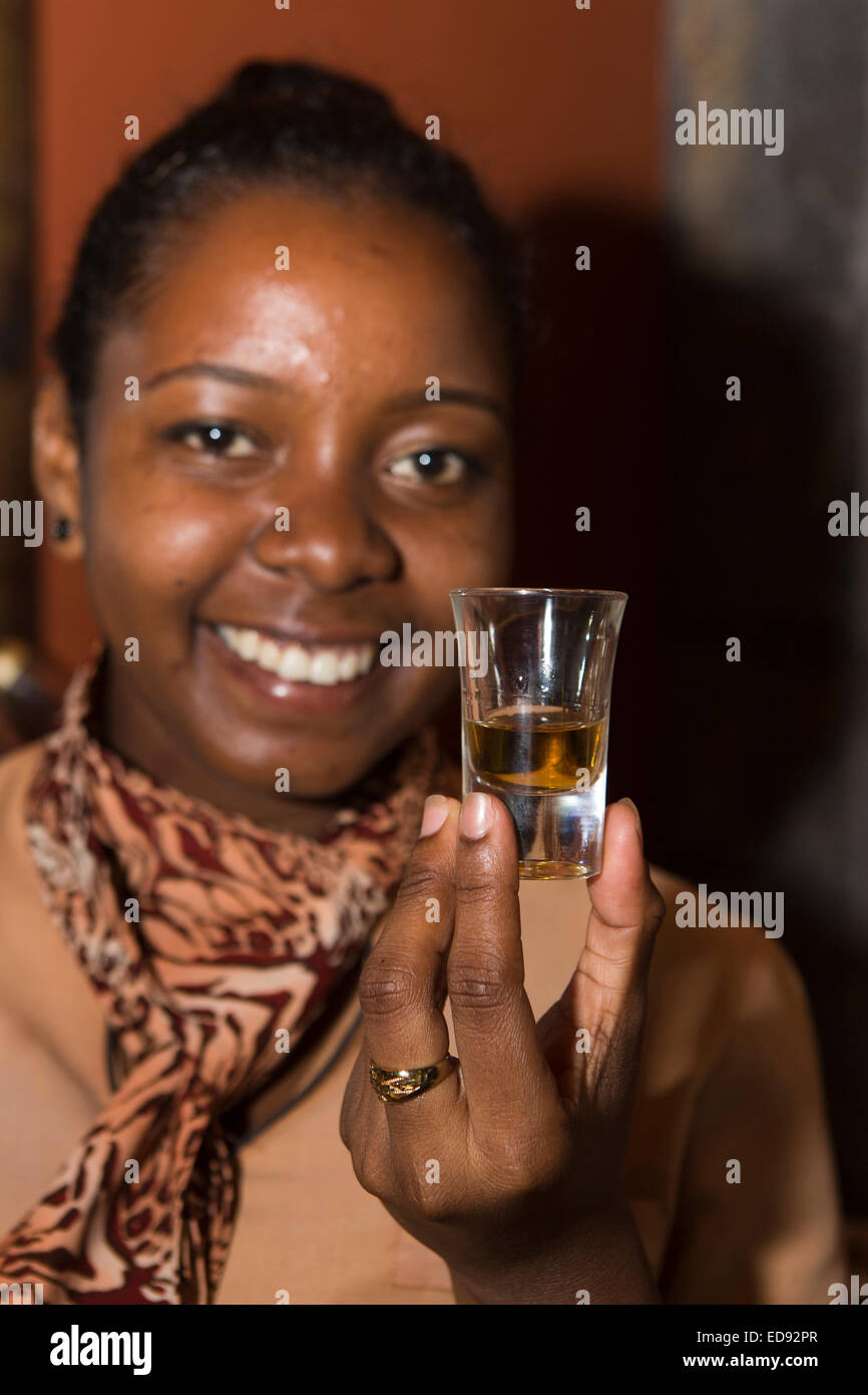 L'Ile Maurice, Chamarel, rhum, rhumerie visite d'usine, female tour guide holding verre de rhum Banque D'Images