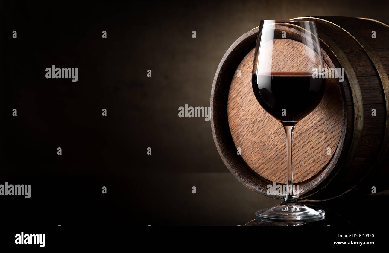 Verre de vin rouge et le baril sur fond brun Banque D'Images