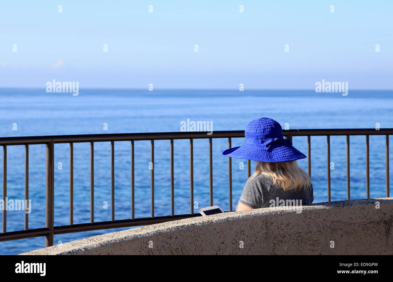 Femme lisant ebook avec vue sur l'océan Banque D'Images