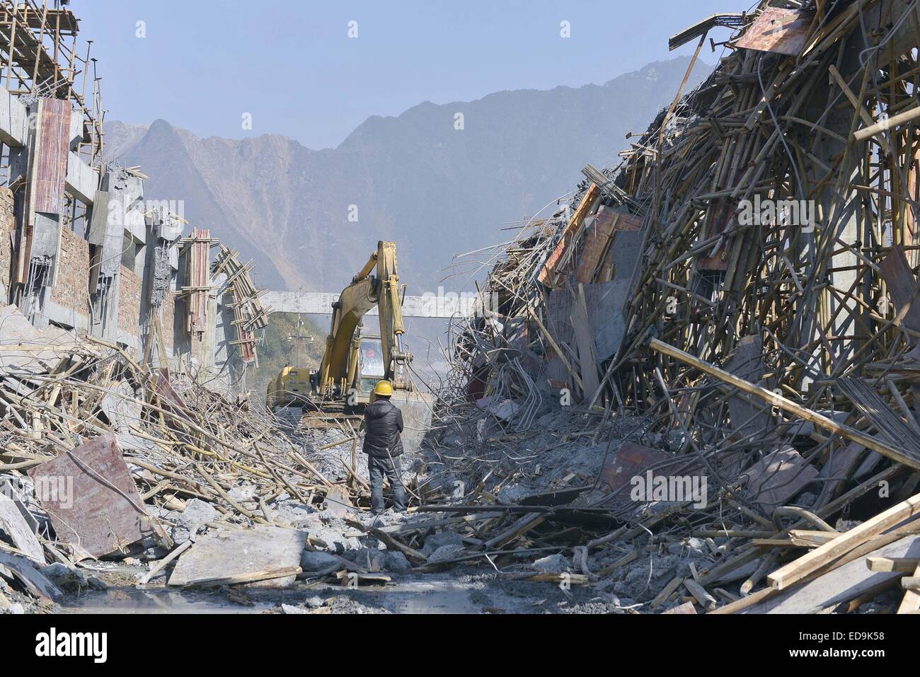 Shanghai, Chine, province du Hunan. 3 janvier, 2015. Un travailleur se dresse sur les ruines d'un bâtiment site après un échafaudage sur le toit et s'est effondré en Chenzhou, province de Hunan, en Chine centrale, 3 janvier 2015. Cinq travailleurs ont été tués et un est resté absent en raison de l'effondrement qui s'est produit à environ 5:10 p.m. vendredi lorsque 11 travailleurs étaient sur le point de terminer les travaux de construction à une machine d'atelier de réparation d'une section locale nonferrous metal company based in Shanghai city. Credit : Zhong Lei/Xinhua/Alamy Live News Banque D'Images