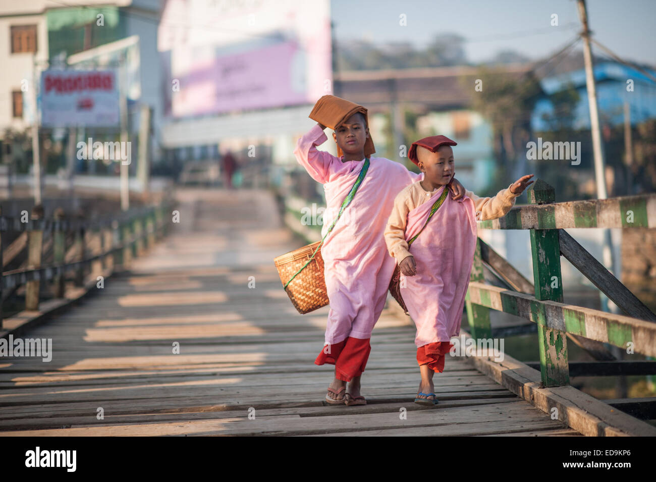Deux jeunes moniales à pied par une passerelle au-dessus de la rivière Nam Pilu tôt le matin Banque D'Images
