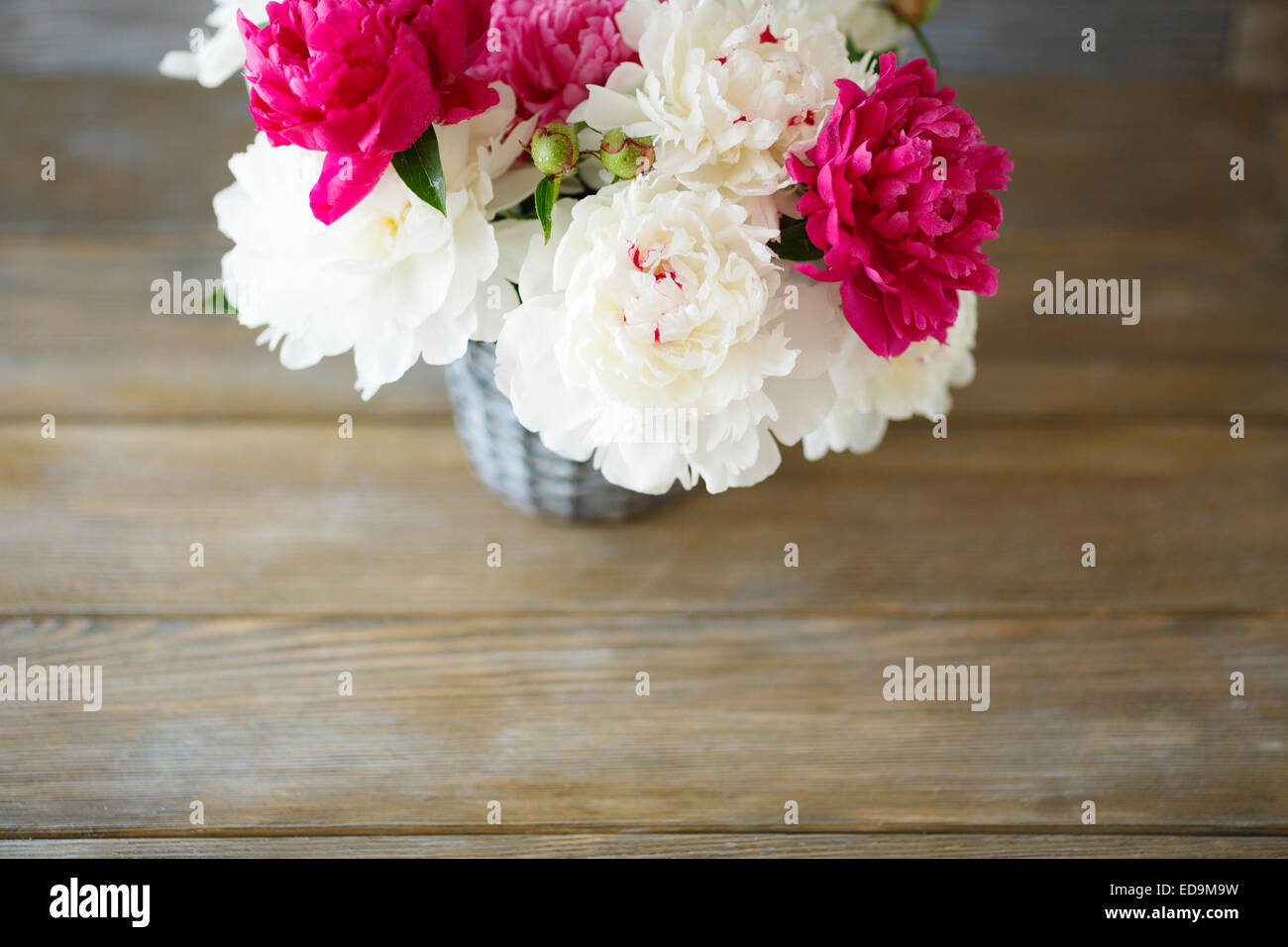 Bouquet de pivoines dans un vase, fond de bois Banque D'Images