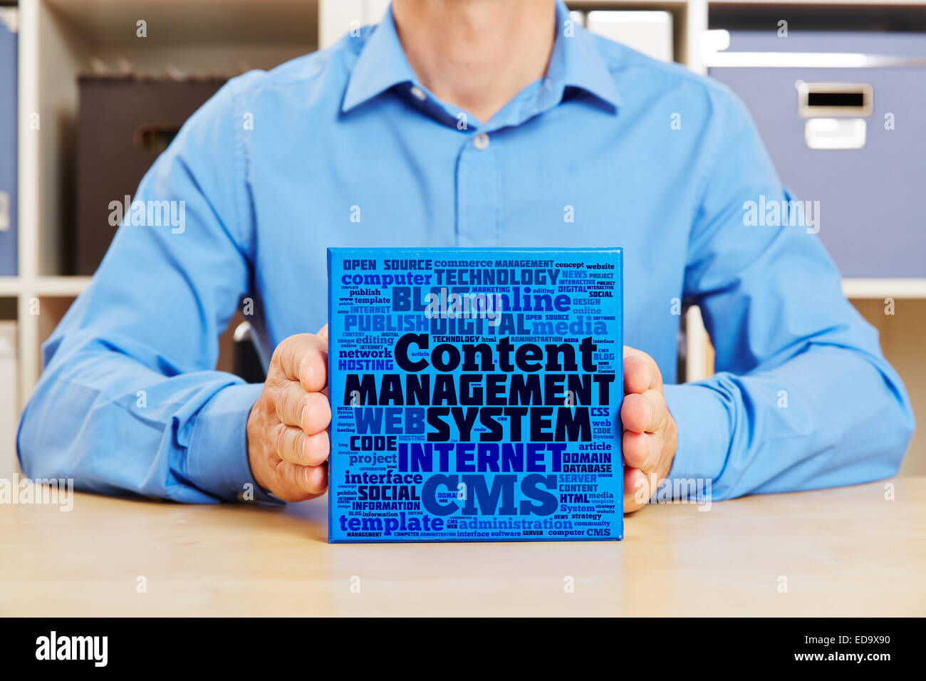 Mains tenant Content Management System concept sur une case bleue Banque D'Images