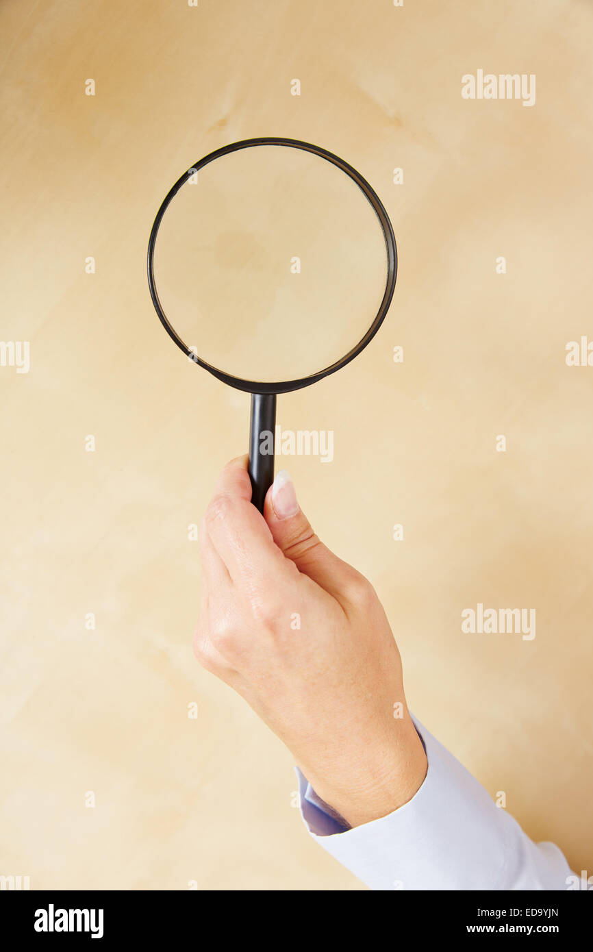 Une main de femme tenant une grosse loupe simple Photo Stock - Alamy