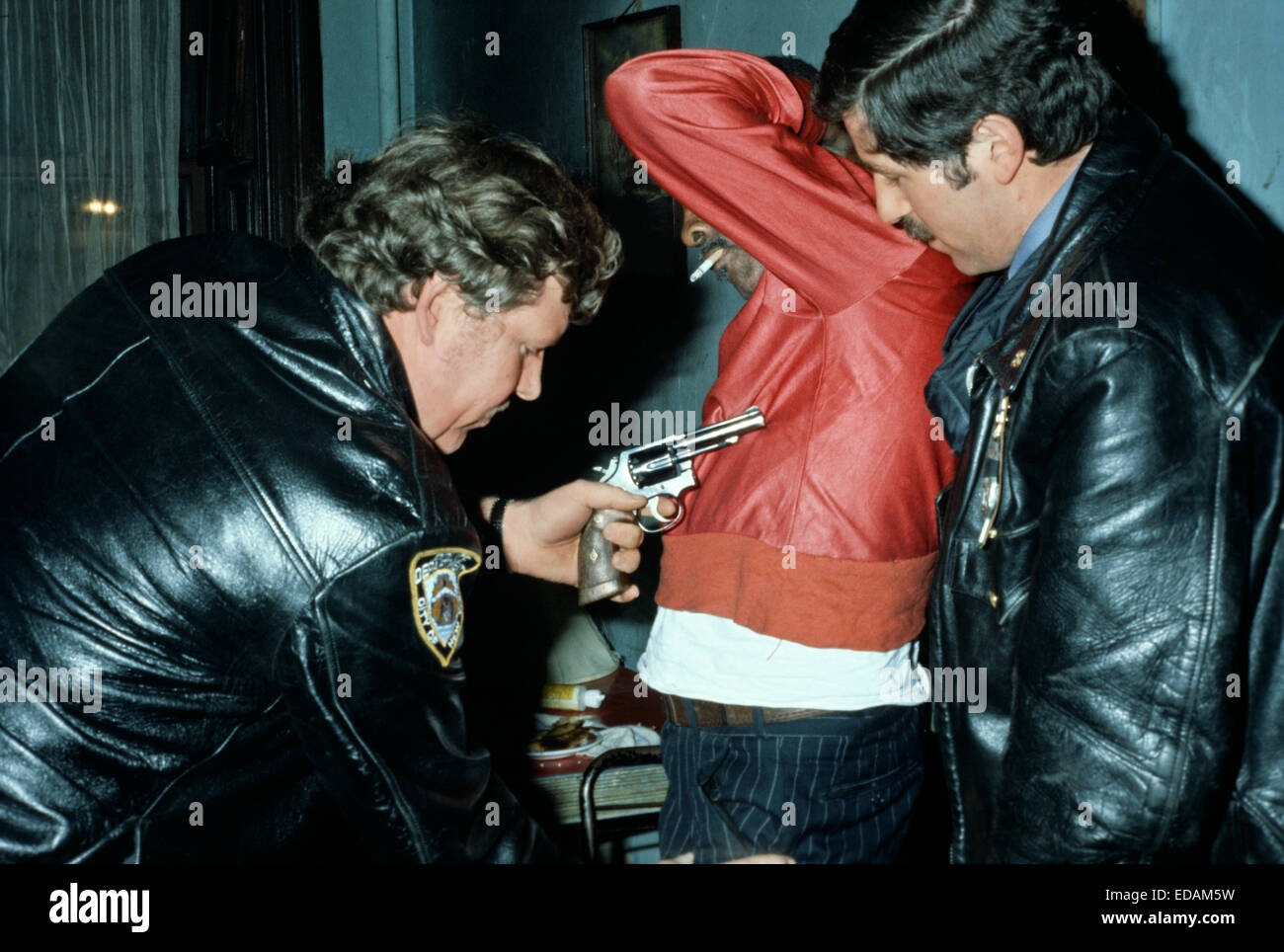 USA, HARLEM, NEW YORK - avril 1978. 28e arrondissement policiers arrêtant African American man lors de la recherche de la drogue et des armes à feu dans la région de Harlem. Banque D'Images