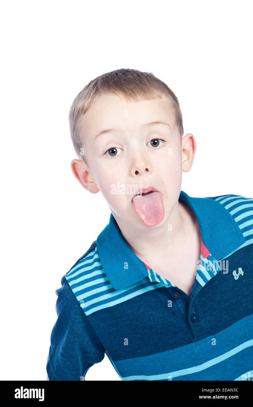 Boy sticking tongue out in studio Banque D'Images