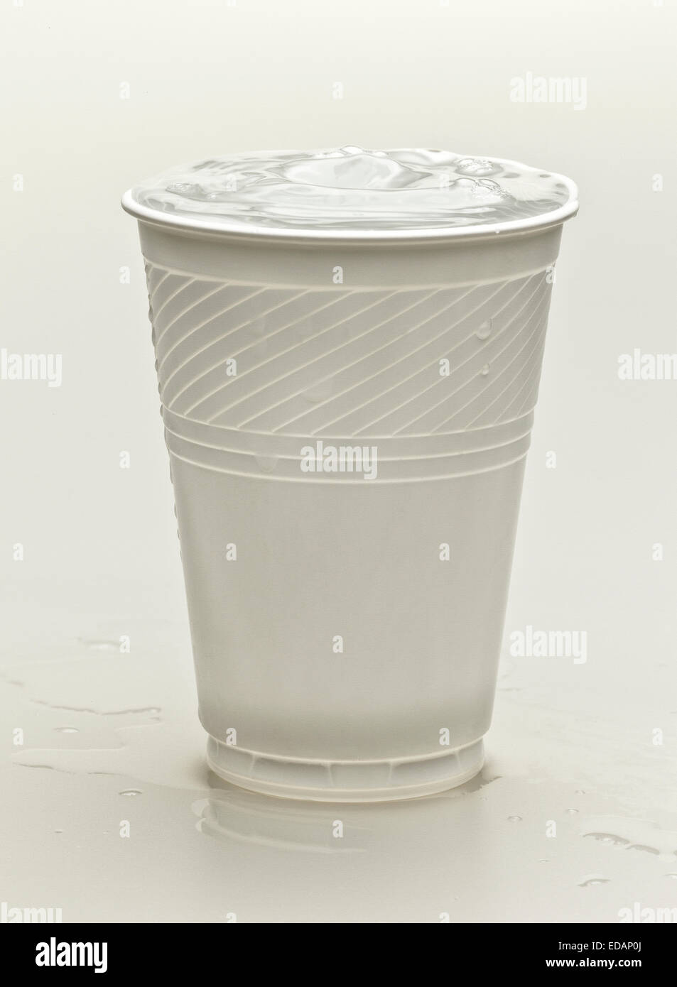 Une tasse en plastique blanc d'un fond blanc contenant de l'eau pour une boisson rafraîchissante Banque D'Images