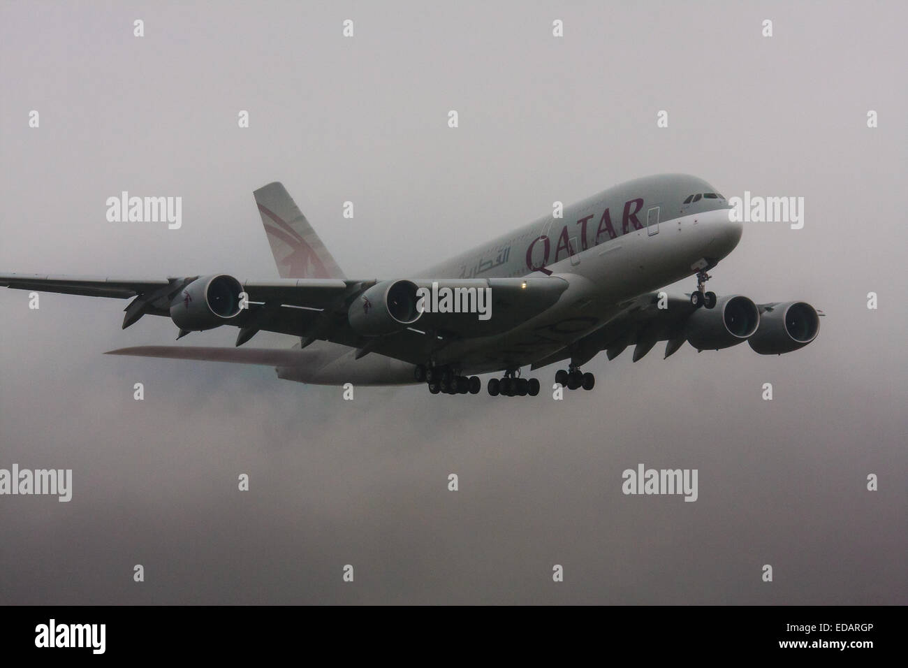 3 janvier 2015, l'aéroport de Heathrow, Londres. Les nuages bas et la pluie fournissent des conditions idéales pour observer service et 'vortex' débourrage comme humidité se condense sur les ailes d'avion à l'atterrissage. Avec la piste visible uniquement à la dernière minute, plusieurs avions ont dû effectuer une 'go-round', abandonnant leurs premières tentatives à la terre. Sur la photo : avec de l'eau les surfaces de contrôle en continu de ses Airbus A380 Le Qatar vient de se poser sur la piste d'Heathrow 27L . Banque D'Images