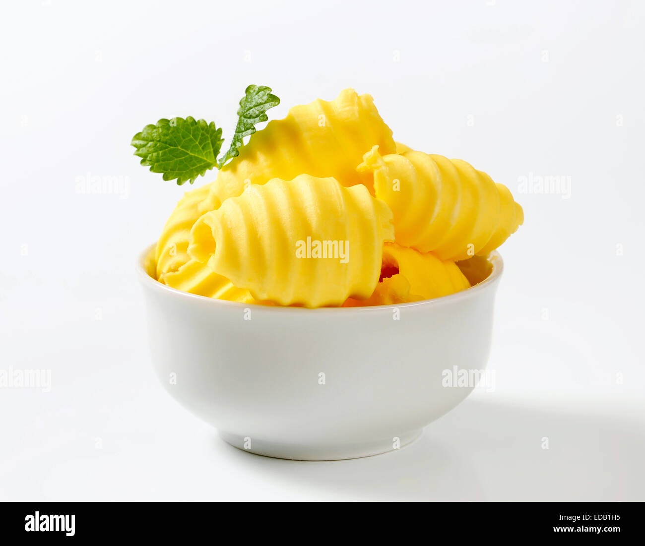 Les boucles de beurre frais dans un bol Banque D'Images