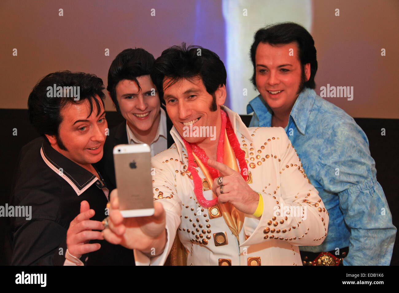 Quatre imitateurs d'Elvis Presley hommage ou artistes posent pour une photographie selfies, lors d'un concours, UK Banque D'Images