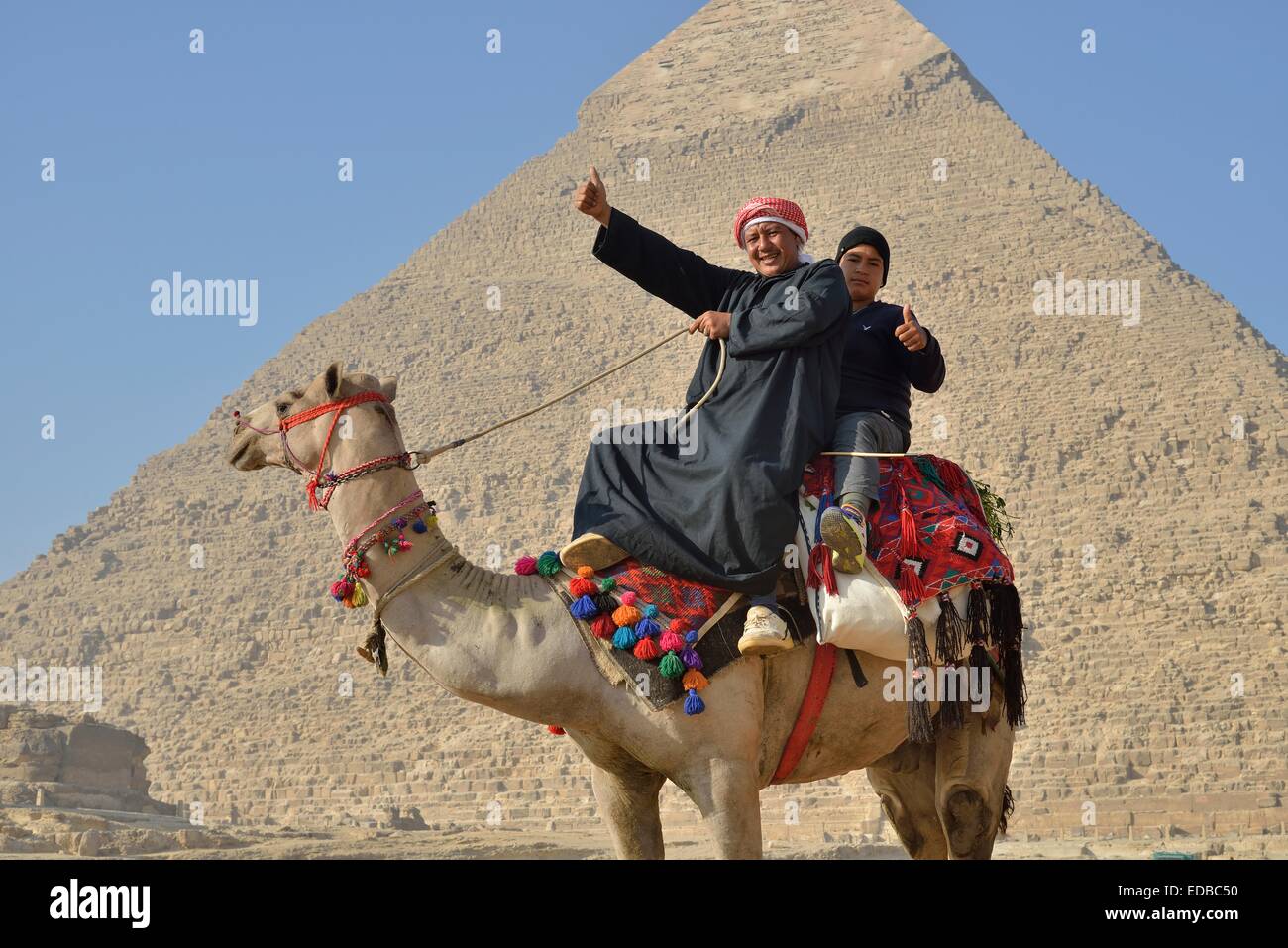 Les propriétaires de chameaux sur un chameau en face de la pyramide de Khéphren, Giza, Egypte Banque D'Images