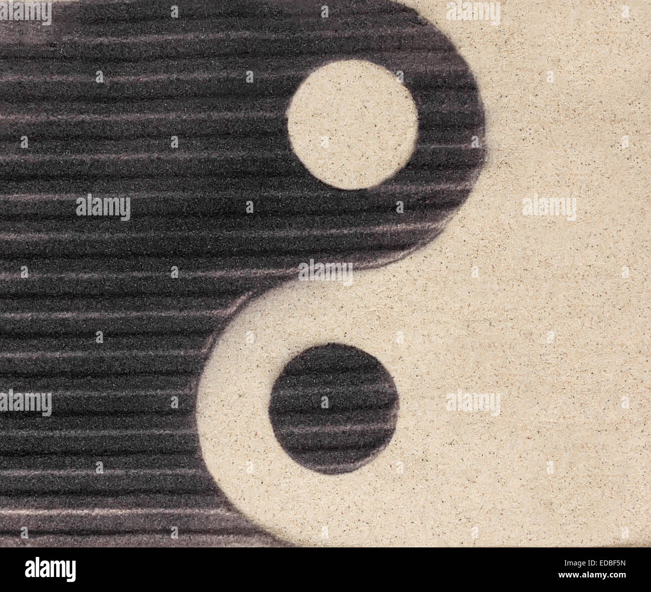 Symbole yin-yang sur le sable comme l'arrière-plan Banque D'Images