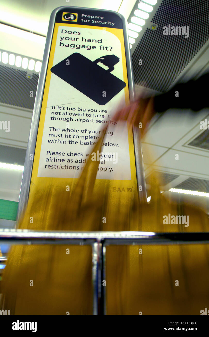 Une femme est vérifie que son sac à main correspond à la stricte de critères à l'aéroport de Heathrow. Banque D'Images