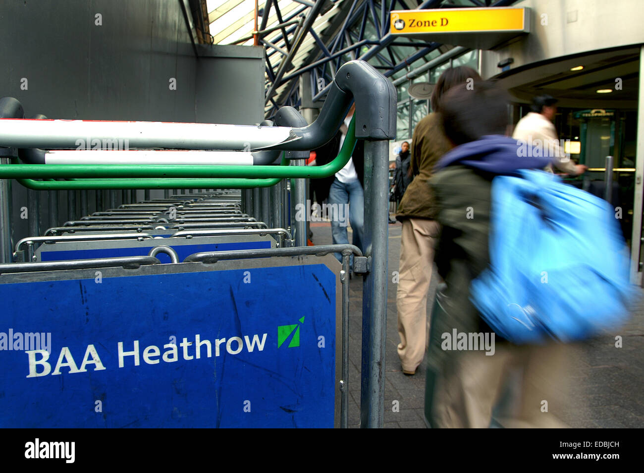 Photo montre : un passager en direction de la zone d'enregistrement à l'aéroport de Heathrow. Banque D'Images
