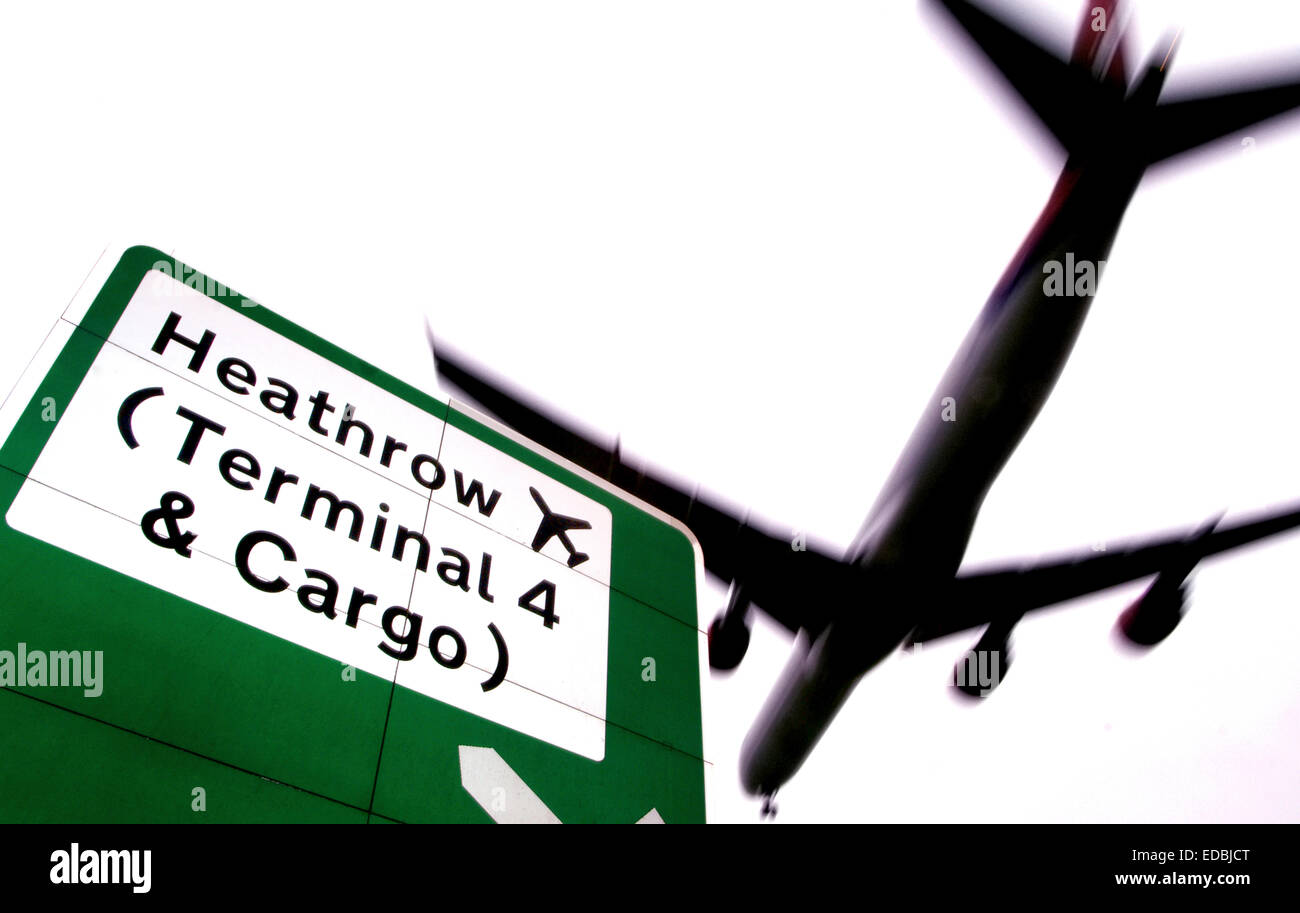 Un avion volant au-dessus des panneaux routiers près de l'Aéroport International d'Heathrow, Londres. Banque D'Images