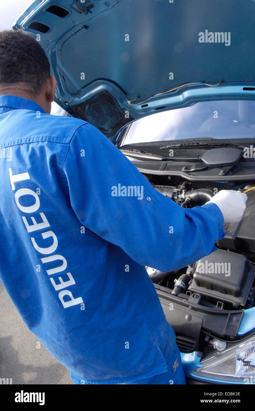 Un mécanicien de voiture au travail sur Peugeot 206. Banque D'Images