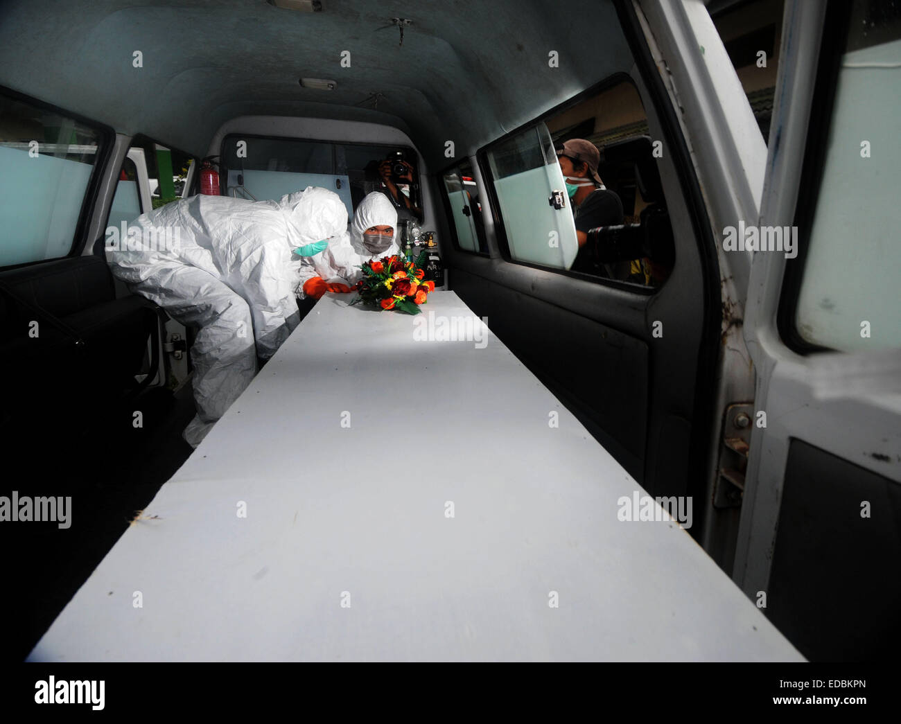 (150105) -- Pangkalan Bun, janv. 5. 2015 (Xinhua) -- les militaires indonésiens et les bénévoles charger un cercueil contenant le corps d'une victime de vol AirAsia QZ8501 à une ambulance à Pangkalan Bun, l'Indonésie. 5 janvier, 2015. Trois plans d'AirAsia l'égard des victimes d'accidents ont été livrées à l'Indonésie Centre de recherche d'AirAsia par un hélicoptère exploité par national indonésien de l'agence de recherche et de sauvetage (BASARNAS) le lundi, ce qui rend le nombre de corps envoyés à l'ordre d'évacuation post atteint 37. (Xinhua/ti'Kuncahya B.) Banque D'Images