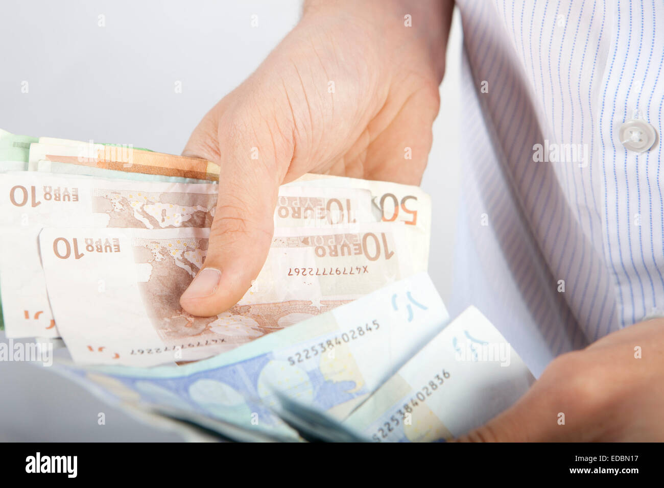 Un homme comptant diverses dénominations de l'Euro Banque D'Images