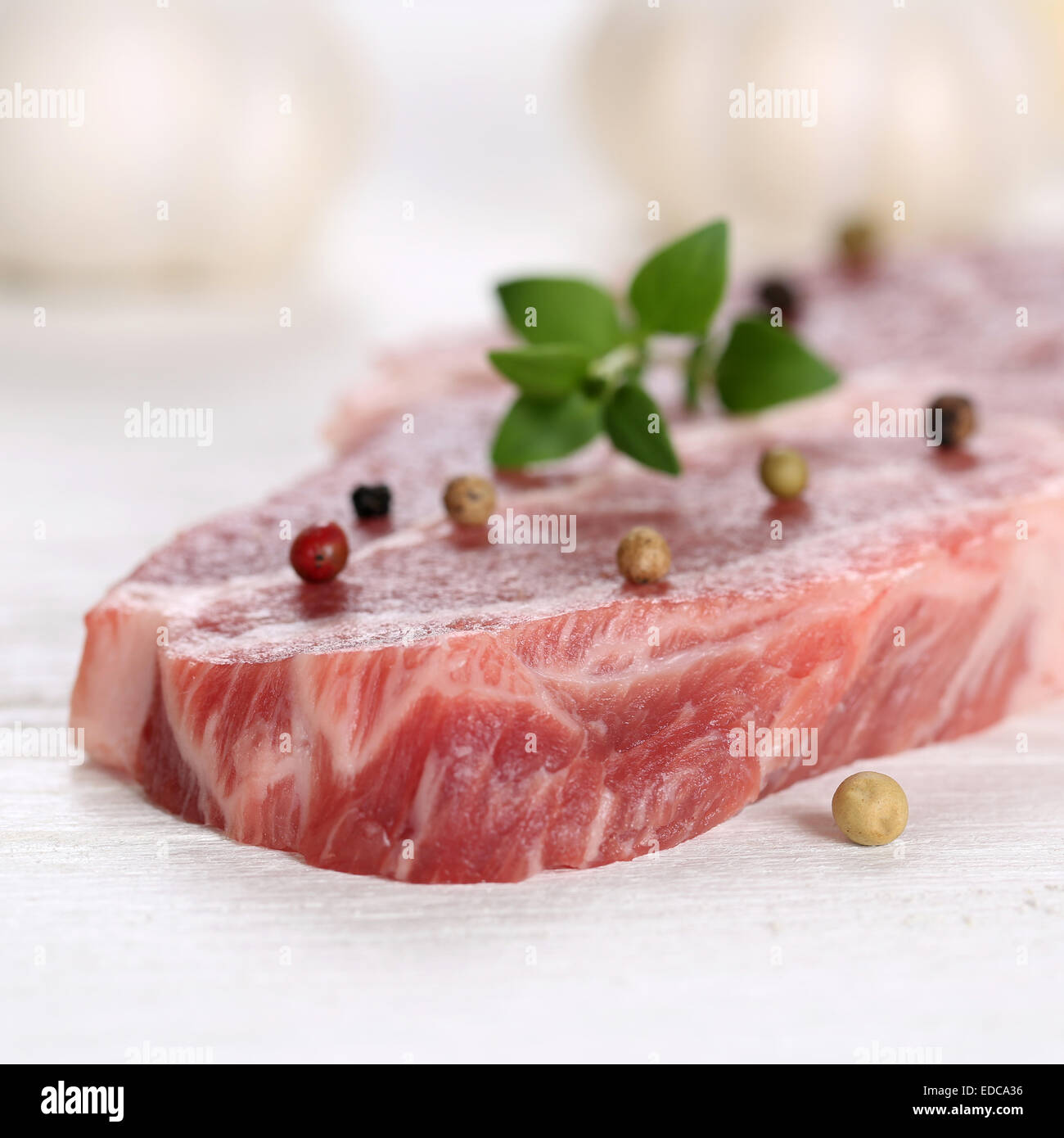 La préparation des aliments la viande de porc cru steak au poivre escalope sur une table en bois Banque D'Images