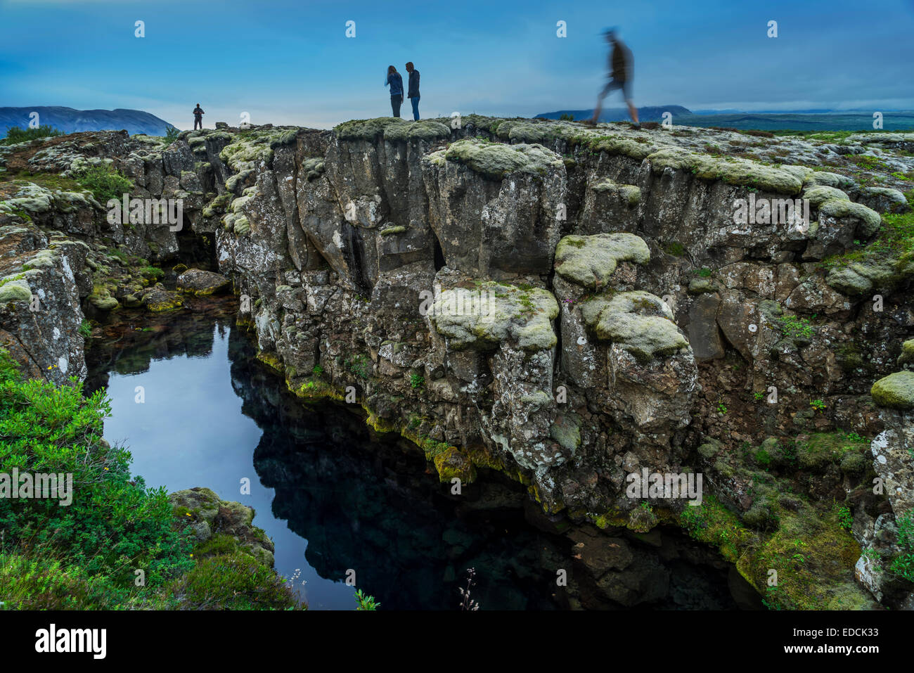 Personnes debout par Flosagja fissure, le Parc National de Thingvellir, Islande Banque D'Images