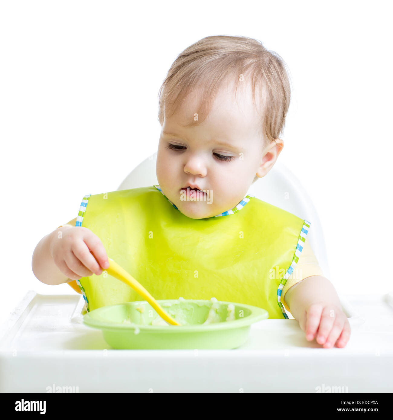 Fille enfant de manger seul avec une cuillère Banque D'Images