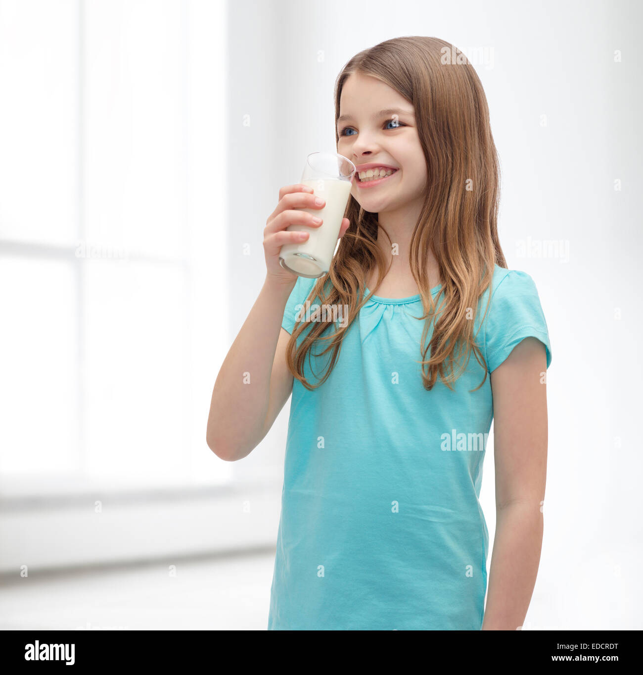 Smiling little girl boire du lait en verre Banque D'Images