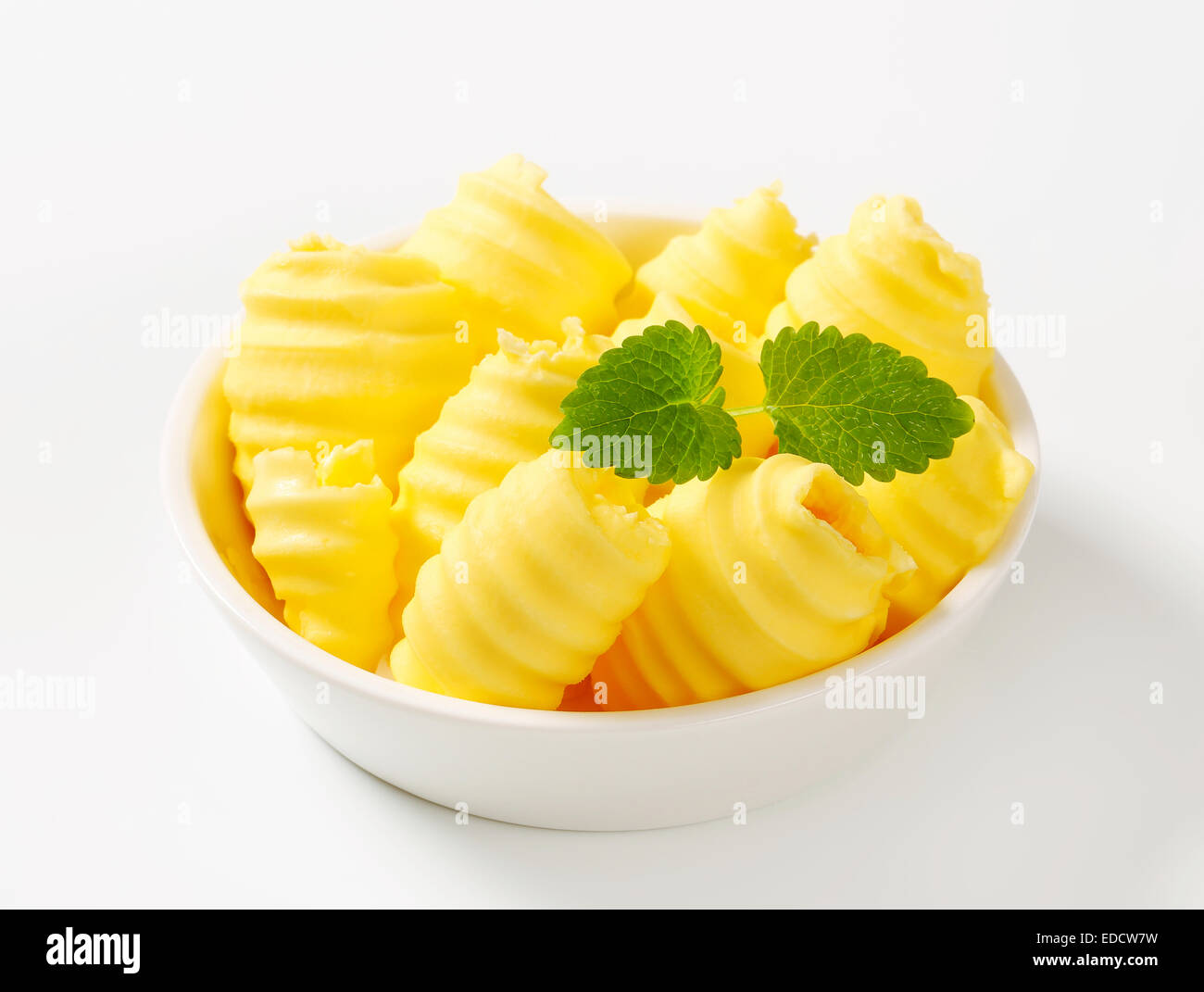 Les boucles de beurre frais dans un bol Banque D'Images