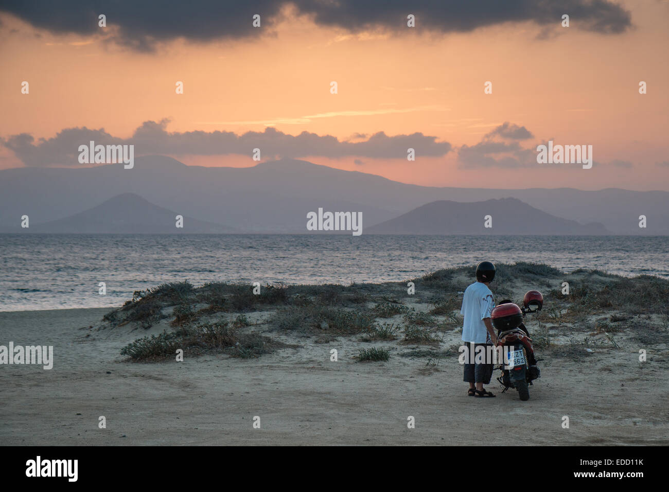 Avec l'homme à la moto au coucher du soleil à Naxos, îles grecques, Grèce Banque D'Images