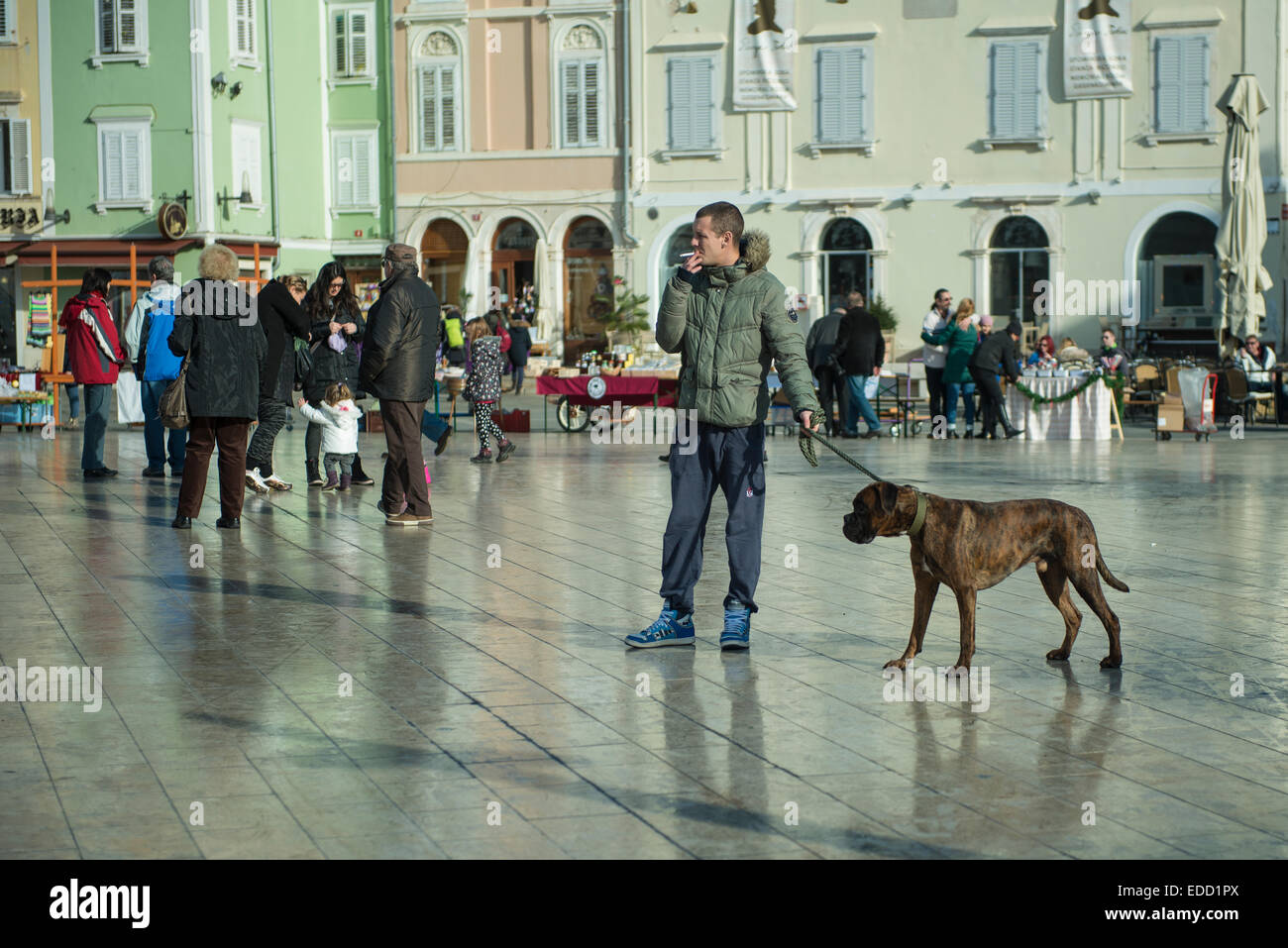 Un homme avec un chien marron dans la place Tartini à Piran, Slovénie Banque D'Images