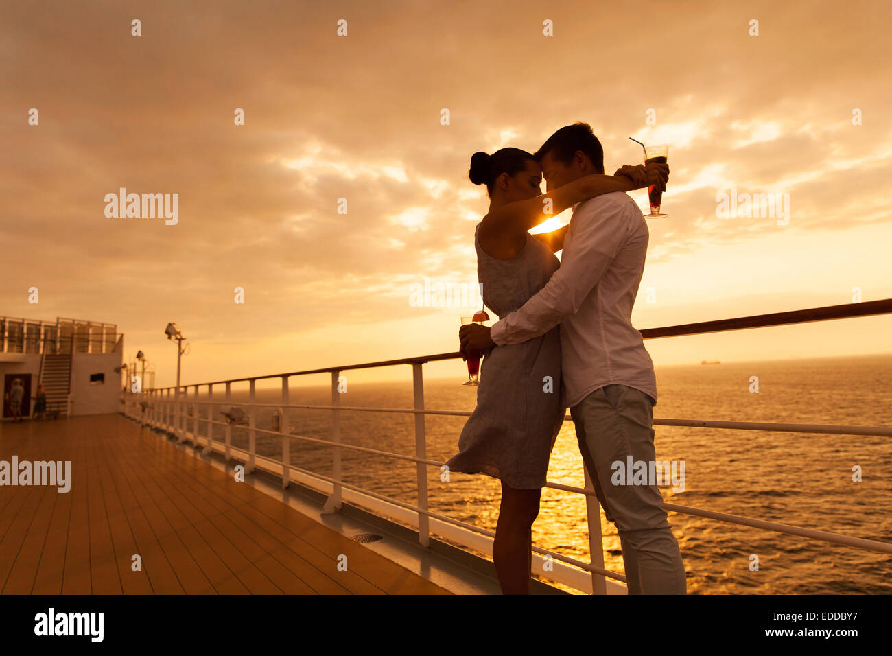 Couple romantique au coucher du soleil avec les yeux fermés sur un bateau de croisière Banque D'Images