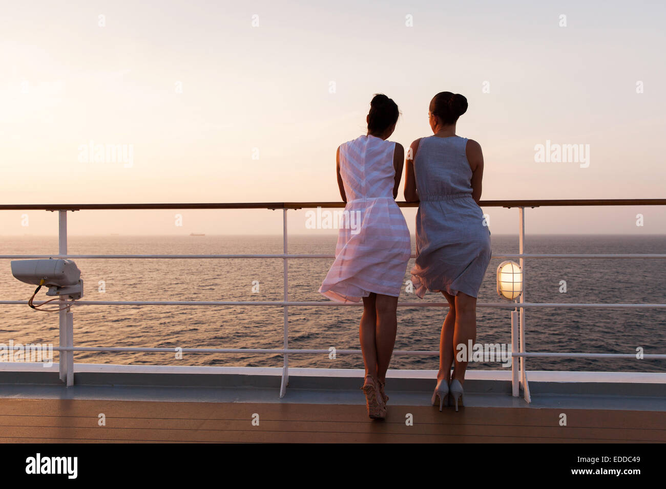 Vue arrière de la femme à la recherche au lever du soleil sur un bateau de croisière Banque D'Images